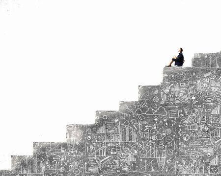 Bored young businesswoman sitting alone on ladder stepsの写真素材