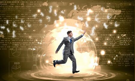 Running young businessman trying to catch dollar signs falling from aboveの写真素材