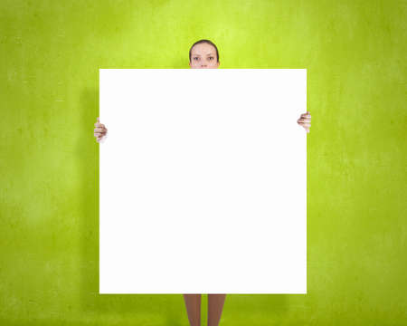Young woman showing white blank banner. Place for textの写真素材
