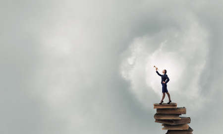 Young pretty businesswoman playing melody on trumpetの写真素材