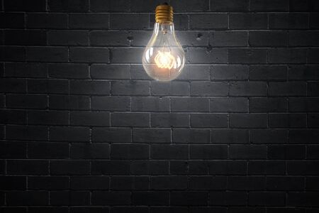 Glowing glass light bulb on concrete backgroundの写真素材