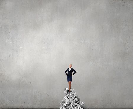 Confident businesswoman standing on top of gearsの写真素材