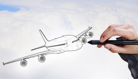 Person drawing airplane model on sky backgroundの写真素材