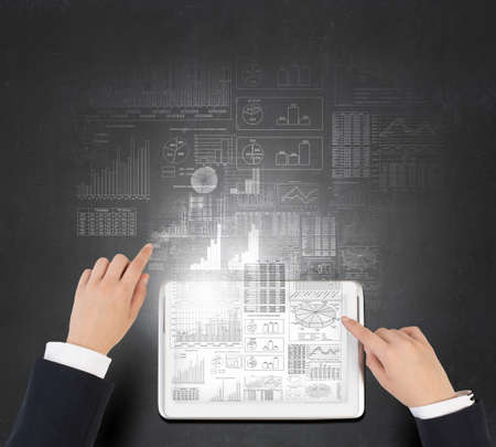 Businessman analyzing financial statistics displayed on tablet screen