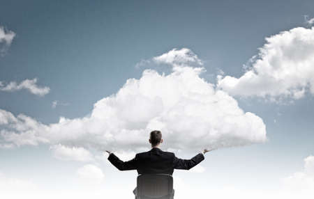 Back view of businessman in chair holding white cloudの写真素材
