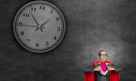 Young businesswoman in red cape acting like super hero