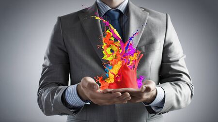 Male hands holding paint splashes and icons in palmsの写真素材