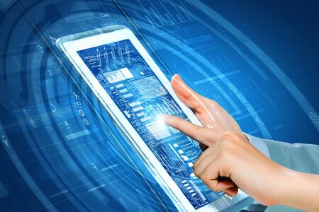 Close up of finger touching blue toned screen on tablet pc