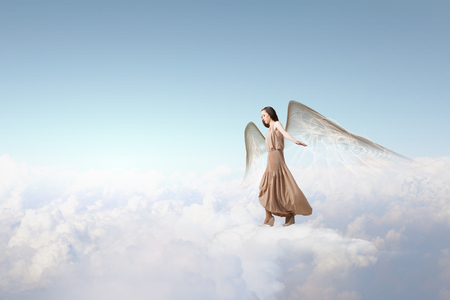 Attractive woman with angel wings on sky backgroundの写真素材
