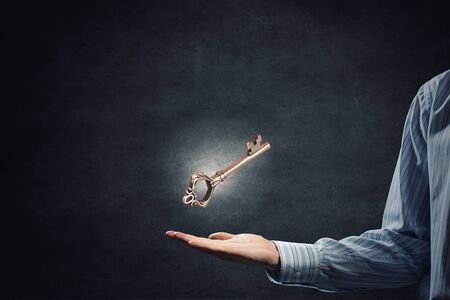 Close up of businessman hand showing key to successの写真素材