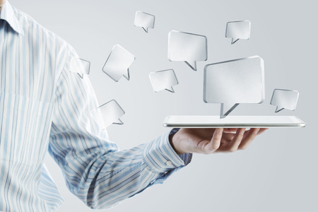 Close up of businessman hand holding tablet and glass symbolsの写真素材