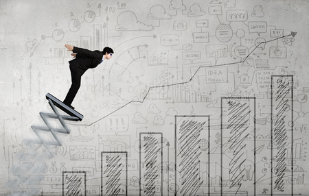Businessman jumping on springboard as progress conceptの写真素材