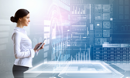 Businesswoman with tablet pc against high tech blue backgroundの写真素材