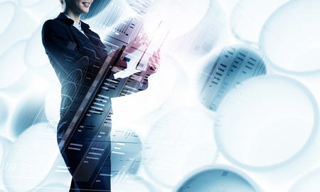 Businesswoman with tablet pc against high tech backgroundの写真素材