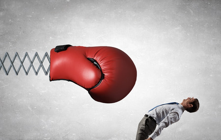 Young determined businessman fighting boxing glove on springの写真素材