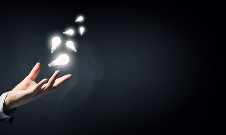 Businessman with illuminated glass light bulb in handの写真素材