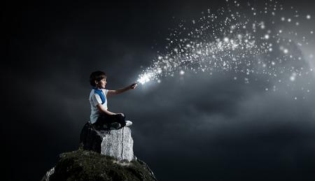Cute school boy sitting on top and using his smartphoneの写真素材