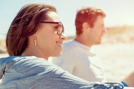 Portrait of young woman on beach with his friends on backgroundの写真素材