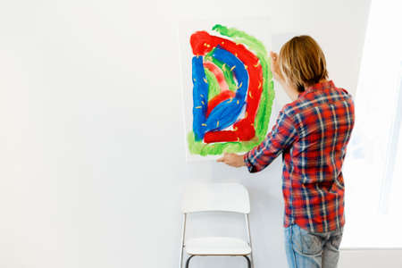 Young male artist standing with his pictureの写真素材