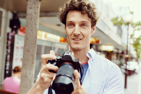 Professional photographer taking picture in cityの写真素材