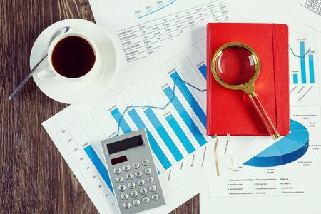 financial charts and graphs and a cup of coffee