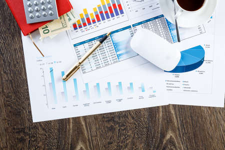 financial charts and graphs and a pen on the office table