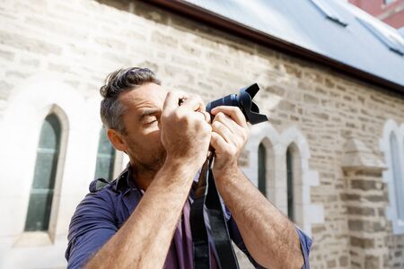 Professional photographer taking picture in cityの写真素材