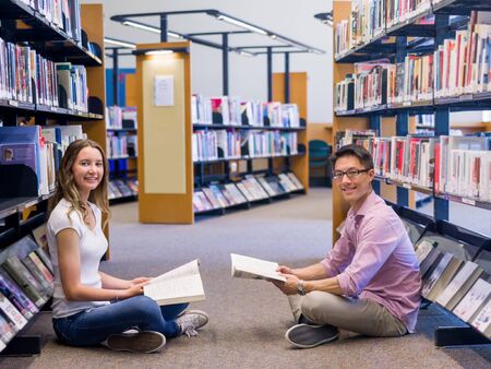 Two young students working together at the library