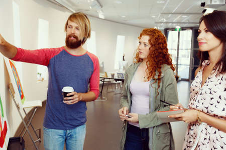 Young people standing in a gallery and contemplating abstract artworkの写真素材