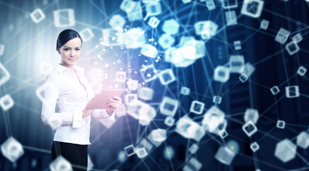 Businesswoman with tablet pc against high tech blue backgroundの写真素材