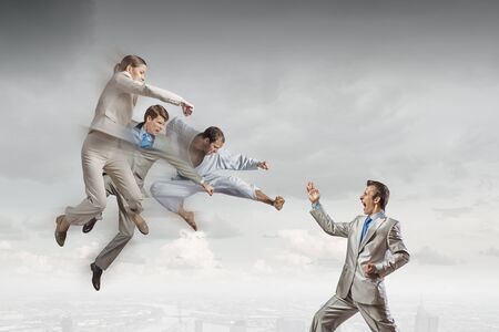 Young determined karate businessman fighting with businesspeopleの写真素材