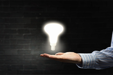 Businessman with illuminated glass light bulb in handの写真素材