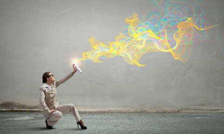 Young businesswoman in glasses using spray balloonの写真素材