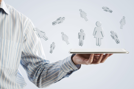 Close up of businessman hand holding tablet and glass symbolsの写真素材