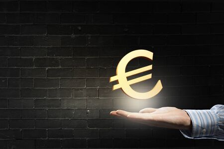 Hand of businessman holding euro sign in palmの写真素材