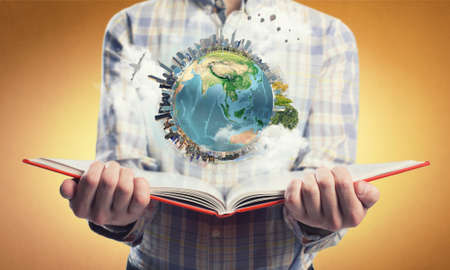 Young man with opened book in hands. Elements of this image are furnished by NASAの写真素材