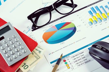 financial charts and graphs and a pen on the office tableの写真素材