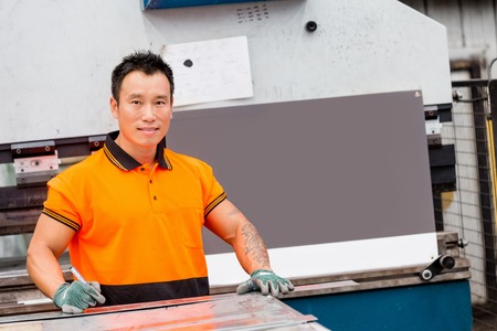 portrait of asian worker in production plant working on the factory floor