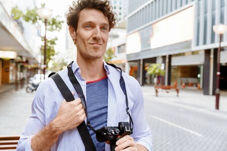 Happy male tourist in casual clothes in city walkingの写真素材