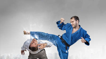 Young determined karate man fighting with businessman in suit