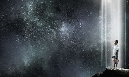 Cute little boy with toy bear on rock topの写真素材