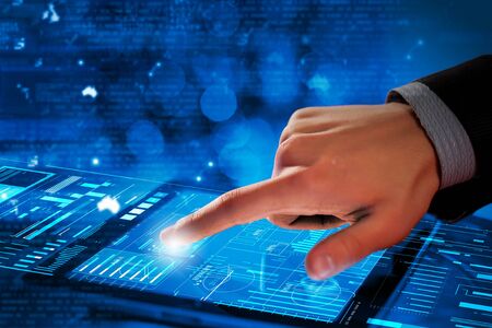 Close up of finger touching blue toned screen on tablet pc