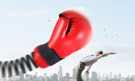 Young determined businessman fighting boxing glove on springの写真素材