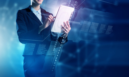 Businesswoman with tablet pc against high tech backgroundの写真素材