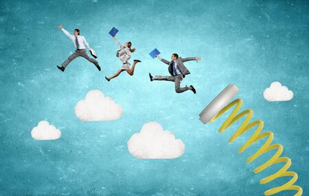 Business people jumping on springboard as progress conceptの写真素材
