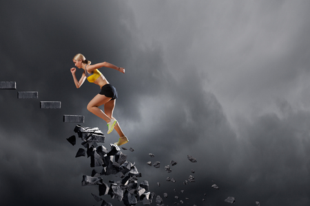 Sports active woman running on stone collapsing ladderの写真素材