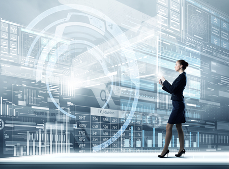 Full body of businesswoman with tablet pc against high tech backgroundの写真素材