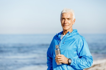 Confident man in sport wear holding bottle with waterの写真素材