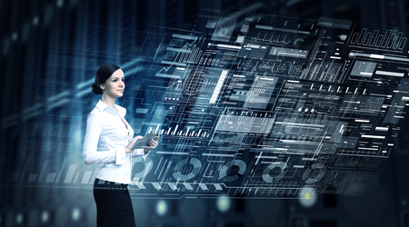 Businesswoman with tablet pc against high tech blue backgroundの写真素材