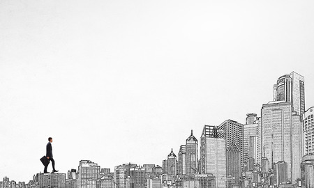 Young businessman walking on buildings roofs representing success conceptの写真素材